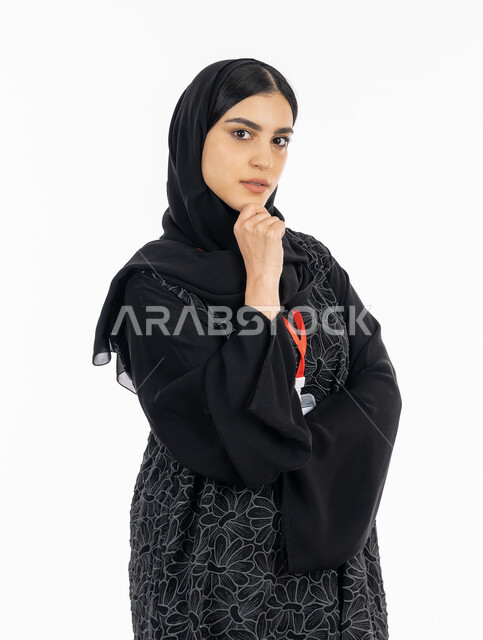 الملامح العربية القوية, مفهوم الأنوثة واللطافة, بورتريه لشابة عربية خليجية إماراتية ترتدي العباءة تنظر إلى الكاميرا, سيدة سعودية تضع يدها على ذقنها بإيماءات التفكير,  خلفية بيضاء