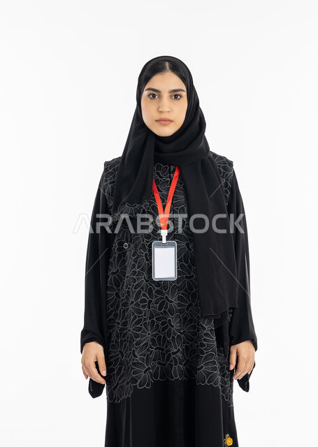 الاهتمام بالمظهر الخارجي, الوقوف باستقامة بإيماءات الجدية والثقة بالنفس, بورتريه لإمرأة عربية خليجية إماراتية ترتدي العباءة تضع بادج شخصي بشريط أحمر, موك أب أبيض مفرغ, سيدة سعودية تنظر إلى الكاميرا, أناقة النساء الخليجيات, خلفية بيضاء