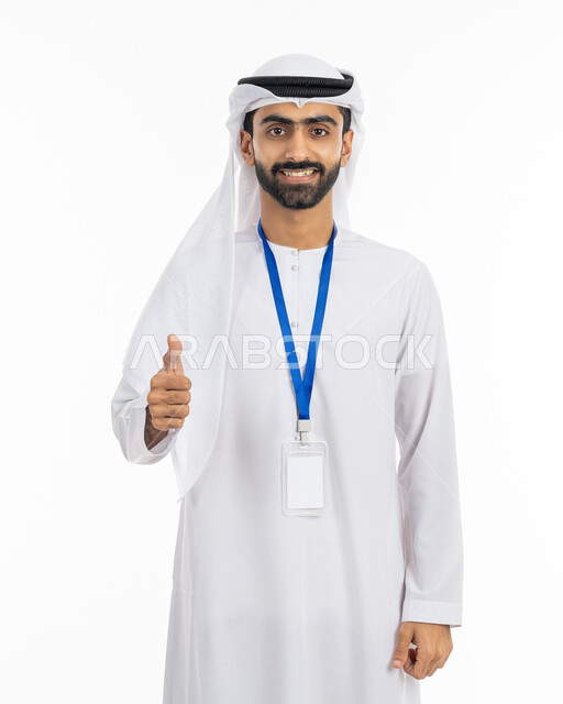 موك أب أبيض مستطيل فارغ, رفع الإصبع بإيماءات الجودة والامتياز, بورتريه لرجل أعمال عربي خليجي إماراتي يرتدي الكندورة والغترة ينظر إلى الكاميرا بابتسامة, ارتداء بادج شخصي, بطاقة تعريفية شخصية باسم الموظف, خلفية بيضاء