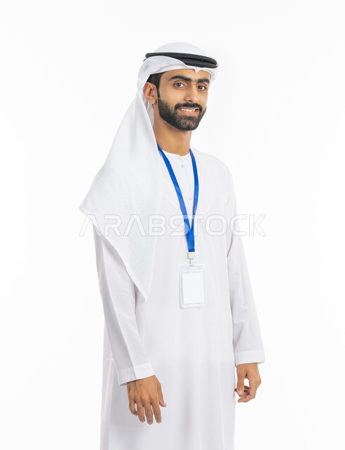 الأناقة والرجولة والوسامة, بورتريه لرجل عربي خليجي إماراتي يرتدي الكندورة والغترة يضع بادج شخصي, الوقوف والنظر إلى الكاميرا بابتسامة, موك أب أبيض مستطيل فارغ, التقاط صور شخصية للوثائق الرسمية, خلفية بيضاء