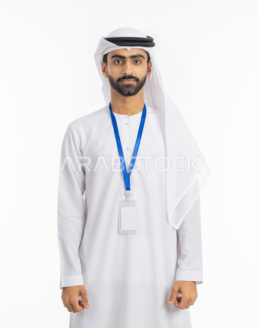 The elegance of youth in the Emirates, wearing a personal badge, the concept of masculinity and concern for external appearance, a mock-up of an ID card cut out in white, a portrait of an Arab Gulf Emirati man wearing a kandora and an Emirati ghutra, looking at the camera seriously and firmly, white background