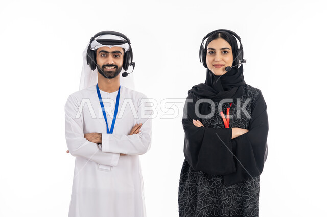 مهن ووظائف خليجية, الوقوف بإيماءات أيدي متقاطعة, بورتريه لإمرأة عربية خليجية اماراتية مبتسمة ترتدي العباءة تعمل في مجال خدمة العملاء, رجل إماراتي ينظر إلى الكاميرا بثقة, استخدام تقنية الهيدفون للرد على استفسارات واستعلامات الزبائن، خلفية بيضاء