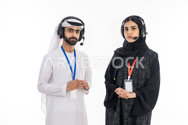 ارتداء بطاقة تعريفية للموظفين, بورتريه لإمرأة عربية خليجية إماراتية ترتدي العباءة تقف بإيماءات الثقة, موظف إماراتي ينظر إلى الكاميرا, العمل في مجال خدمة العملاء, استخدام تقنية الهيدفون, الرد على اسئلة واستفسارات الزبائن, تعزيز مستوى رضا العميل, خلفية بيضاء