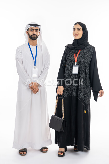 بطاقة تعريفية شخصية, بورتريه لموظف عربي خليجي إماراتي يرتدي الكندورة والغترة يقف بإيدي متقاطعة, الوقوف باستقامة بإيماءات الثقة بالنفس, إمرأة سعودية مبتسمة تنظر إلى الكاميرا, ارتداء كرت أبيض مستطيل فارغ, صورة الجسم بالطول الكامل, خلفية بيضاء