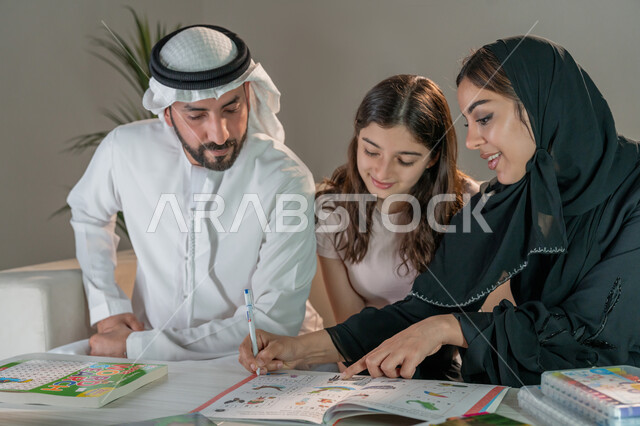 تشجيع ورعاية وتطوير مهارات الابناء، قضاء اوقات عائلية ممتعة في المنزل، عائلة عربية خليجية إماراتية تقوم بتعليم ومشاركة الإبنه بالتلوين والانشطة الفنية الابداعية، استخدام ادوات ومعدات التلوين