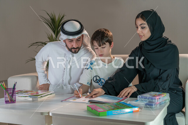 رعاية وتشجيع وتطوير مهارات الابناء، قضاء اوقات عائلية ممتعة في المنزل، عائلة عربية خليجية إماراتية تقوم بتعليم ومشاركة الابن بالتلوين والانشطة الفنية الابداعية، استخدام ادوات ومعدات التلوين