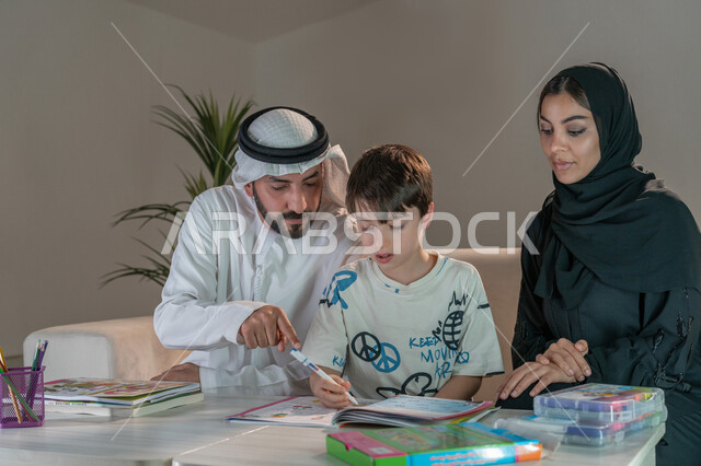 رعاية وتشجيع وتطوير مهارات الابناء، قضاء اوقات عائلية ممتعة في المنزل، عائلة عربية خليجية إماراتية تقوم بتعليم ومشاركة الابن بالتلوين والانشطة الفنية الابداعية، استخدام ادوات ومعدات التلوين