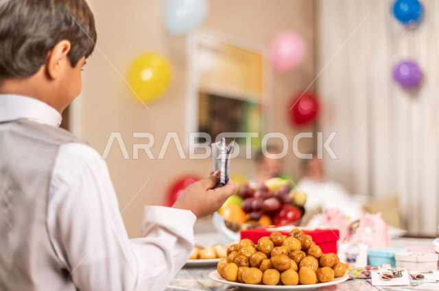 Happy Saudi Arabian Gulf child, wearing elegant Eid clothes, taking Eid, celebrating Eid Al Fitr, Blessed Eid Al Fitr, presenting Eids and sweets, Gergean
