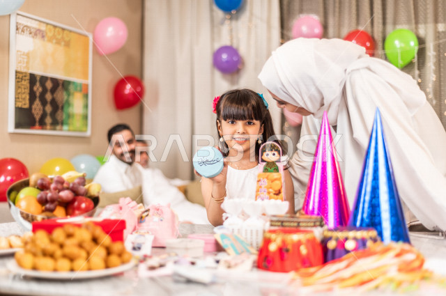Sharing a wonderful atmosphere for a Saudi family inside the house celebrating Eid Al Fitr, Eid Al Fitr Mubarak, family visits and family gatherings, providing Eids and sweets, Gergean