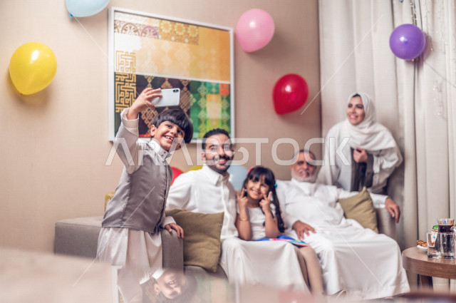 Sharing a wonderful atmosphere for a Saudi family inside the house celebrating Eid Al Fitr, Eid Al Fitr Mubarak, family visits and family gatherings, providing Eids and sweets, Gergean