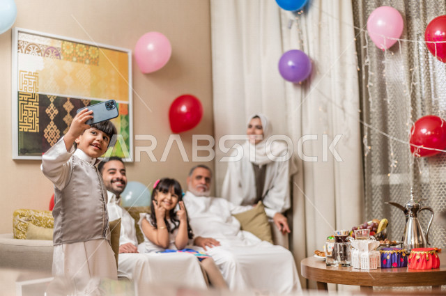 Sharing a wonderful atmosphere for a Saudi family inside the house celebrating Eid Al Fitr, Eid Al Fitr Mubarak, family visits and family gatherings, providing Eids and sweets, Gergean