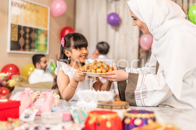 Sharing a wonderful atmosphere for a Saudi family inside the house celebrating Eid Al Fitr, Eid Al Fitr Mubarak, family visits and family gatherings, providing Eids and sweets, Gergean