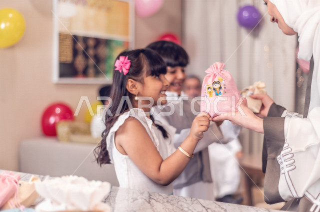 Sharing a wonderful atmosphere for a Saudi family inside the house celebrating Eid Al Fitr, Eid Al Fitr Mubarak, family visits and family gatherings, providing Eids and sweets, Gergean