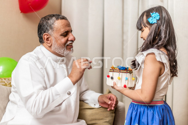 مشاركة اجواء رائعة لطفلة سعودية مع جدها  داخل المنزل ، الاحتفال بعيد الفطر السعيد ، عيد الفطر المبارك ،  الزيارات العائلية وتجمعات الأسر ،  تقديم العيديات و الحلوى ، القرقيعان
