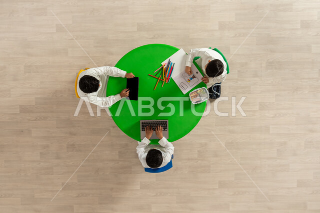 تنمية المهارات الفنية، نشاطات تعليمية إبداعية، بورتريه علوي عامودي لأطفال من المملكة العربية السعودية،  يرتدون الزي السعودي التقليدي، يقومون بالرسم والتلوين بالألوان واستخدام الأجهزة الحديثة، مفهوم الاهتمام بالهوايات، خلفية بيج