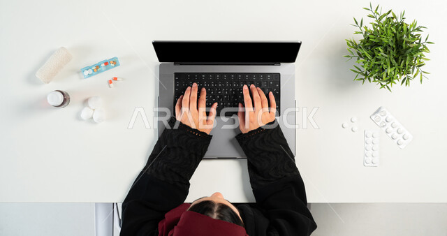 طلب الدواء من الصيدلية الالكترونية، بورتريه علوي عامودي ليدي إمرأة عربية خليجية سعودية تقوم باستخدام جهاز الحاسوب المحمول لشراء الأدوية من خلال المواقع الإلكترونية عبر الانترنت، الحصول على المستحضرات الطبية أونلاين، عرض شاشة سوداء فارغة، خلفية بيضاء