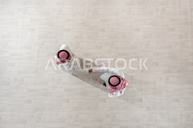 إلقاء التحية والسلام, التعارف والصداقة وتكوين العلاقات, المتعة مع الأصدقاء, بورتريه علوي عامودي لزملاء عمل عرب خليجيين سعوديين يرتديان الثوب التقليدي والشماغ, خروج الموظفين عند انتهاء أوقات الدوام الرسمية, قضاء أوقات ممتعة في العمل, خلفية بيج