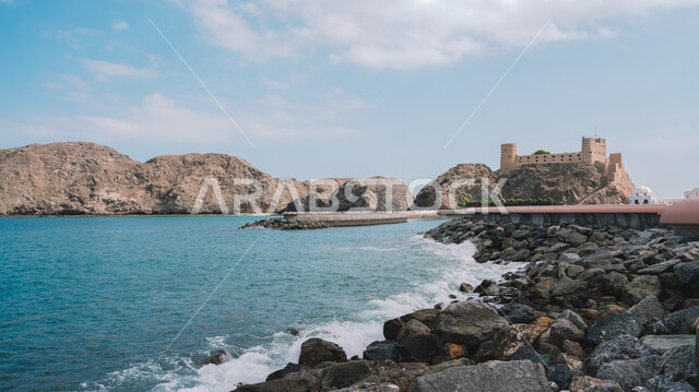المناظر الطبيعية البحرية الهادئة، الفن الهندسي المعماري القديم لقلعة مسقط في سلطنة عمان، المعالم والاماكن السياحية المشهورة في وقت النهار، الواجهة الساحلية المائية لجذب واستقطاب السياح