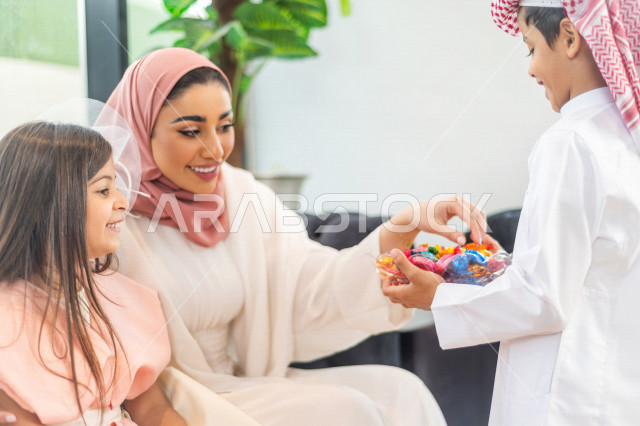 Sharing a wonderful atmosphere for a Saudi family inside the house celebrating Eid Al Fitr, Eid Al Fitr Mubarak, family visits and family gatherings, offering Eids and sweets, Gergean