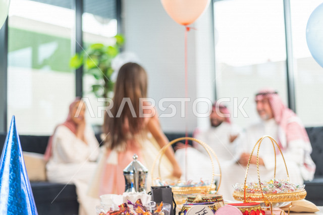 طفلة سعودية خليجية سعيدة ترتدي لباس العيد الانيق ، تشارك الاجواء الاحتفالية الخاصة بعيد الفطر المبارك ، الاحتفال بعيد الفطر السعيد ، عيد الفطر المبارك  ،  تقديم العيديات و الحلوى ، القرقيعان