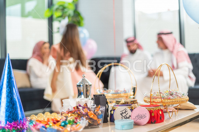 Sharing a wonderful atmosphere for a Saudi family inside the house celebrating Eid Al Fitr, Eid Al Fitr Mubarak, family visits and family gatherings, offering Eids and sweets, Gergean