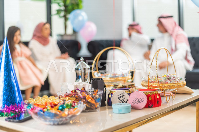 Sharing a wonderful atmosphere for a Saudi family inside the house celebrating Eid Al Fitr, Eid Al Fitr Mubarak, family visits and family gatherings, offering Eids and sweets, Gergean