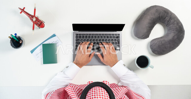 Buying, selling, and cutting airline tickets online, using websites to search for flights, a close-up portrait of a Saudi Gulf Arab man using a laptop, next to him is a passport, a travel ticket, a cup of coffee, and miniature models of airplanes, showing a blank black screen, a white background