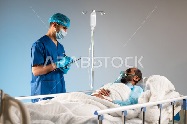 إجراء الفحوصات والمتابعة الدورية للمرضى, تقديم الاستشارات والخدمات العلاجية، بورتريه مقرب لممرض عربي خليجي سعودي يرتدي يونيفورم العمل والكمامة، القيام بتسجيل وتدوين معلومات المريض,  خدمات العناية الطبية في المستشفيات السعودية, خلفية زرقاء