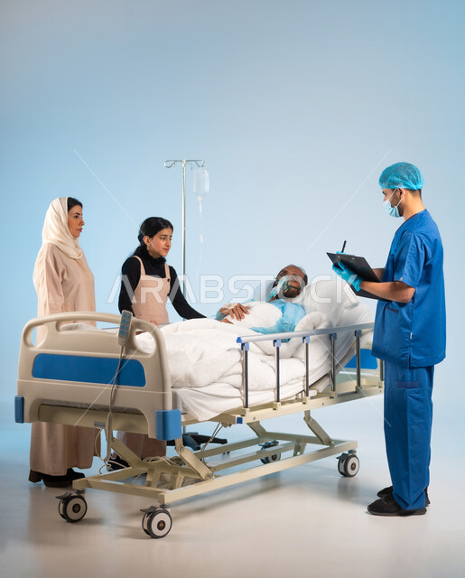 تدوين المعلومات والملاحظات الطبية, تقديم الاستشارات والخدمات العلاجية، تلقي العلاج والعناية, الاهتمام بالمرضى والتشخيص العلاجي لهم, بورتريه لرجل مريض عربي خليجي سعودي يرتدي يونيفورم العمليات مستلقي على السرير يضع كمامة الأكسجين وبجانبه عائلته, خلفية زرقاء