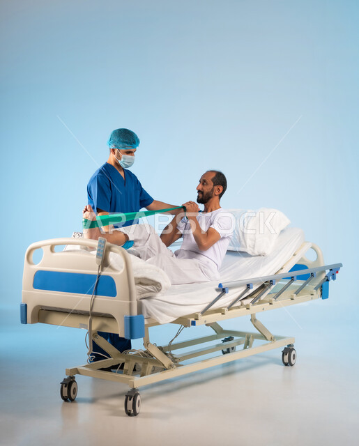 تقديم الاستشارات والخدمات العلاجية للمرضى، بورتريه لممرض عربي خليجي سعودي يرتدي بونيفورم العمل والكمامة يقوم بتقديم العلاج الفيزيائي للمريض، العمل في المراكز الطبية والمستشفيات السعودية، تلقي العلاج والعناية بالمستشفى، مفهوم الطب والرعاية الصحية، خلفية زرقاء