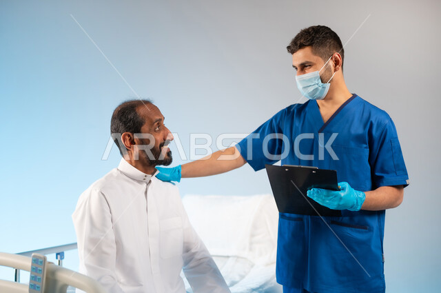 تقديم الدعم النفسي والإشراف الطبي, الفحوصات الطبية والرعاية الصحية في المستشفى, بورتريه مقرب لممرض عربي خليجي سعودي مبتسم يرتدي يونيفورم العمل يقوم بتشخيص الحالة المرضية, اتباع اجراءات الوقاية من فايروس كورونا, مهن ووظائف طبية في السعودية، خلفية رمادية
