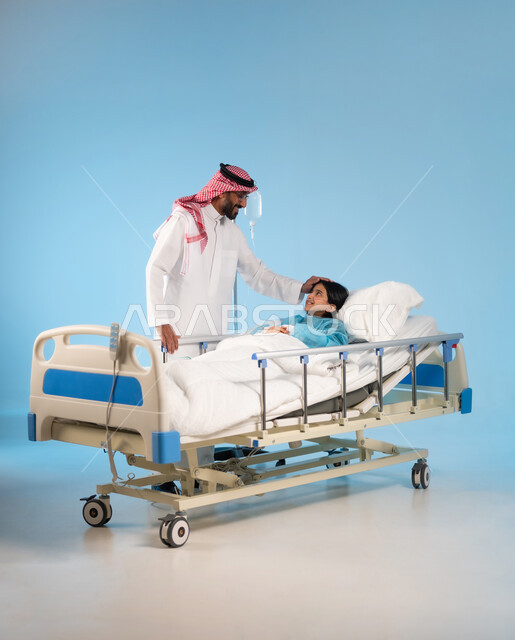 خوف الأهل على الأبناء وتقديم الدعم النفسي لهم, بورتريه لأب عربي خليجي سعودي يرتدي الثوب التقليدي والشماغ يضع يديه على رأس ابنته المريضة وينظر إليها بإيماءات العطف والحنان, تلقي العلاج والعناية في المستشفى, مفهوم الطب والرعاية الصحية, خلفية زرقاء