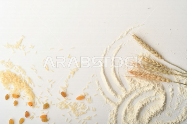 مجموعة من الأرز والزبيب والقمح والطحين والعملات المعدنية على خلفية بيضاء