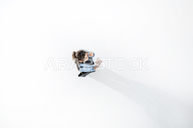 وضع كريم الأساس لإخفاء عيوب البشرة، الإهتمام بالجمال والمظهر الخارجي, دورات تعليمية لمكياج تتوريال، خبيرة سعودية لمستحضرات التجميل، بورتريه عامودي علوي لإمرأة عربية خليجية سعوديه ترتدي الزي الكاجوال الصيفي تحمل بيدها البيوتي بلندر والمرآة، خلفيه بيضاء