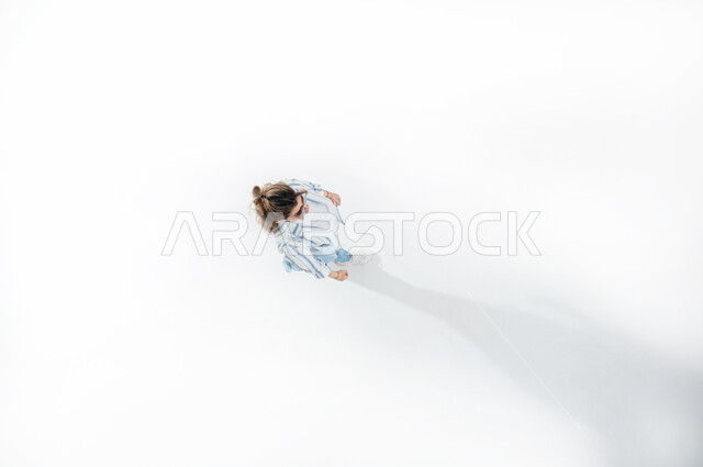 المشي والذهاب الى مكان ما، بورتريه عامودي علوي لسيده عربيه خليجيه سعوديه ترتدي الزي الكاجوال الصيفي والنظاره الشمسيه تتحرك وتسير باتجاه مكان معين، النشاط والحركه واداء التمارين الرياضيه، التنزه في المولات والحدائق والاماكن العامه، خلفيه بيضاء