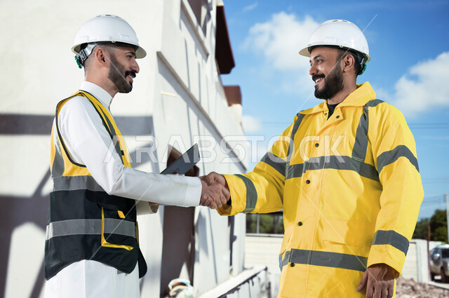 التصافح لنجاح وانجاز خطة العمل المتفقة, ميناء شحن البضائع و الحاويات التجاريه، مهندسان عربيان سعوديان خليجيان يقومان بالاشراف على توصيل ونقل الكونتينرات بإستخدام جهاز التابلت، استخدام الآلات المتطوره الحديثه في الإستيراد والتصدير, رؤية مستقبلية 2030.