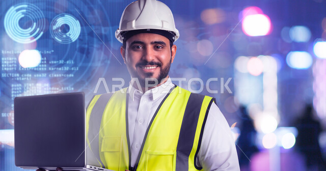 دراسة أساسيات المشروع عبر تطبيقات الحاسوب المحمول، التكنولوجيا والمجالات الهندسية, صورة مقربة لمهندس عربي خليجي سعودي مبتسم يرتدي الخوذة وسترة الحماية يعمل على جهاز اللابتوب، النظر الى الكاميرا بتعابير السرور، خلفية ضبابية مع ايقونات هولوجرامية