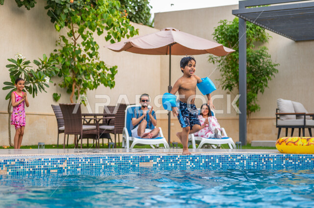 الأنشطة ترفيهية أثناء الإجازة، الاستعداد للقفز في المسبح، الأجواء الصيفية الممتعة، الاستمتاع بقضاء عطلة صيفية سعيدة، ولد عربي خليجي سعودي يرتدي عوامة السباحة ويقفز في بركة مائية