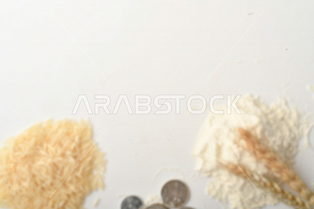 مجموعة من الأرز والزبيب والقمح والطحين والعملات المعدنية على خلفية بيضاء