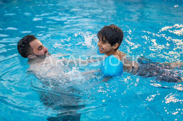 الرحلات الترفيهيه الممتعة, قضاء أوقات ممتعة ومنعشة في فصل الصيف،  أب عربي سعودي خليجي يعلم ابنه مهارة السباحة في بركة مائية، الاستمتاع في إحدى مسابح المملكة العربية السعودية، شاليهات ومنتجعات سياحية