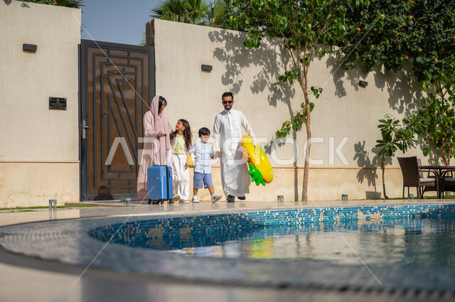 المشي على حدود البركة المائية، رحلة سياحية ترفيهية، الاستمتاع في إجازة الصيف، عطلة صيفية وأجواء عائلية سعيدة، عائلة عربية خليجية سعودية تقضي اوقات ممتعة في احد المنتجعات السعودية