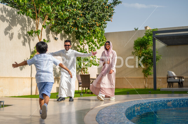 Meeting with the family and the joy of returning from travel, gestures indicating enthusiasm and happiness, a Saudi Gulf Arab man wearing a traditional dress, opening his hands to embrace his son, building a strong relationship with the children, the role of the father in the children’s lives, spending enjoyable family times in tourist resorts.