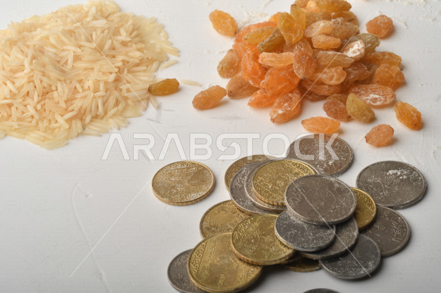 مجموعة من الأرز والزبيب والقمح والطحين والعملات المعدنية على خلفية بيضاء