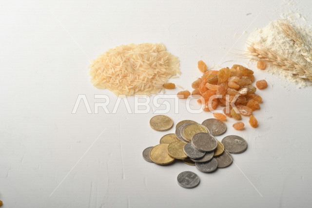 مجموعة من الأرز والزبيب والقمح والطحين والعملات المعدنية على خلفية بيضاء