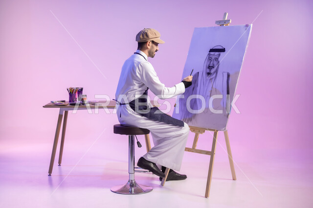 الجلوس أمام لوحة معالم وعلم المملكة، بورتريه لرسام عربي خليجي سعودي يرتدي الثوب التقليدي ومريلة الرسم، ممارسة الهوايات المفضلة، القيام برسم لوحات وطنية، استخدام ريشة الرسم و التلوين، استذكار اليوم الوطني، حب الوطن والإنتماء إليه، الجسم بالطول الكامل، خلفية ملونة
