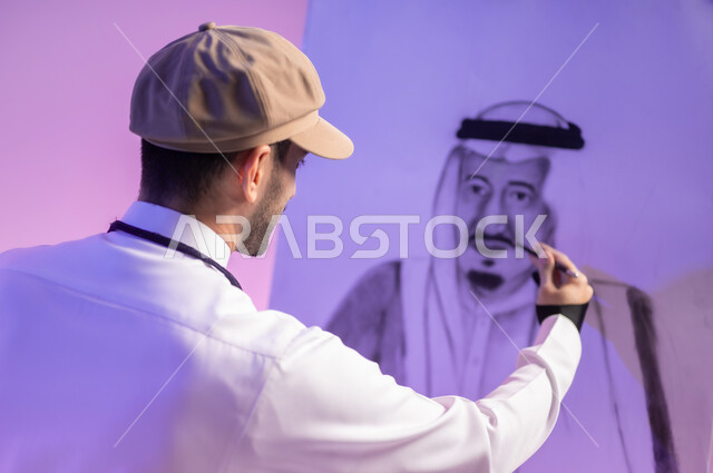 القيام برسم لوحات وطنية، استخدام ريشة الرسم و التلوين، ممارسة مهارات مسلية وممتعة، الجلوس أمام لوحة معالم وعلم المملكة، بورتريه مقرب لرسام عربي خليجي سعودي يرتدي الثوب التقليدي ومريلة الرسم، استذكار اليوم الوطني، حب الوطن والإنتماء إليه، خلفية ملونة