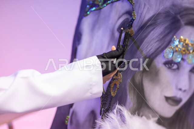 ممارسة هواية الرسم والفنون اليدوية، حب وشغف الفروسية، استخدام ريشة التلوين والرسم، الجلوس أمام لوحة خيل عربي أصيل أبيض وبجانبه إمرأة، عشق الحصان السعودي الأصيل، بورتريه مقرب لرسامة عربية خليجية سعودية ترتدي اللباس الكاجوال ومريلة الرسم، خلفية ملونة