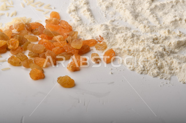 حفنة من الأرز والقمح والزبيب والطحين على خلفية بيضاء