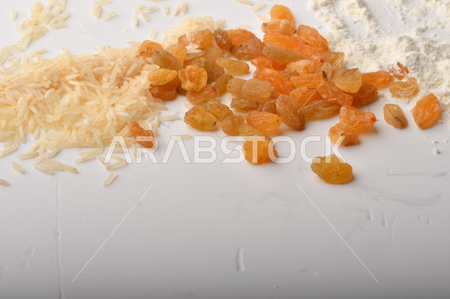 حفنة من الأرز والقمح والزبيب والطحين على خلفية بيضاء