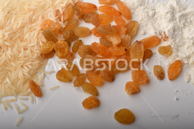 حفنة من الأرز والقمح والزبيب والطحين على خلفية بيضاء